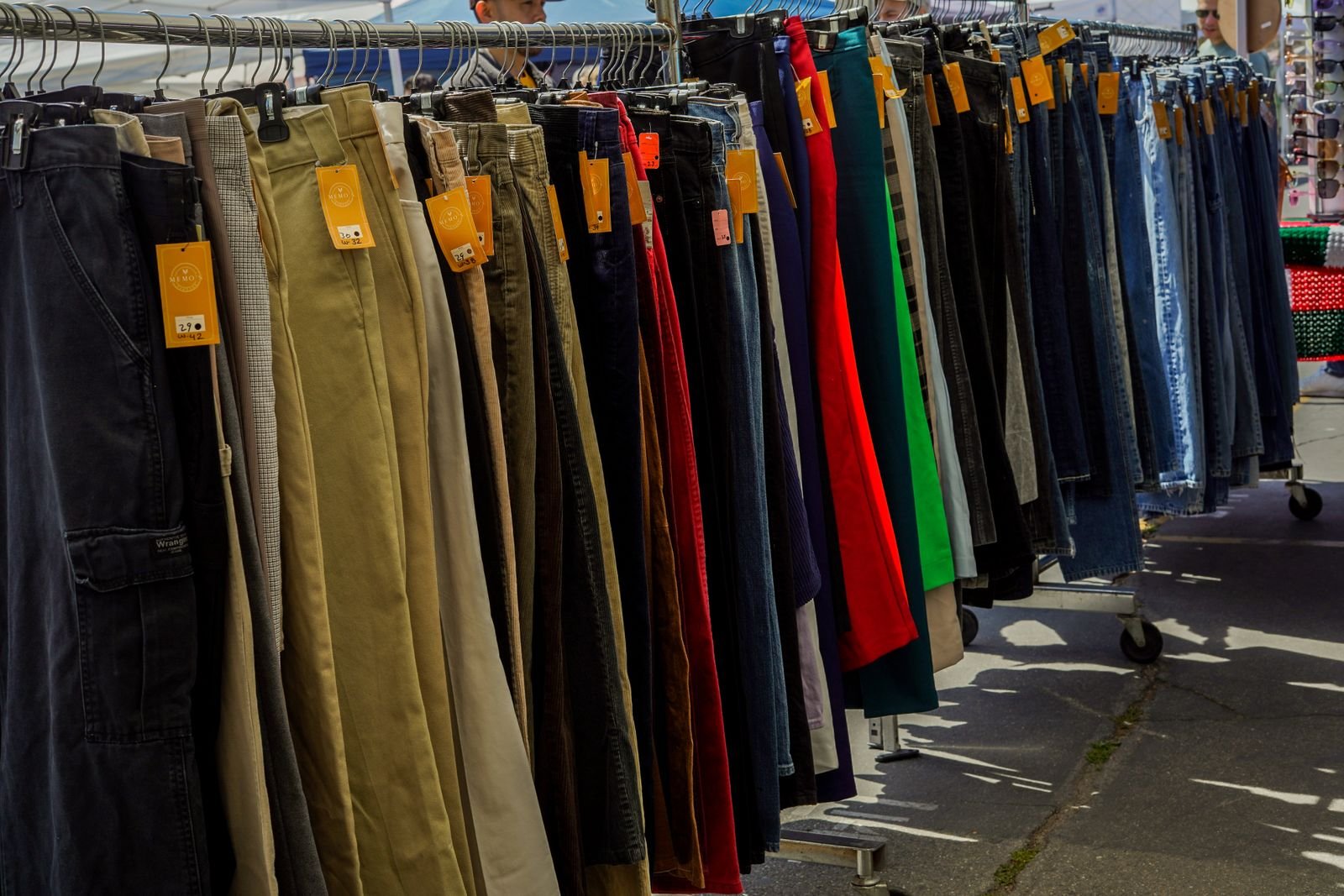 Rack di vestiti usati con cartellini del prezzo a un mercato all'aperto